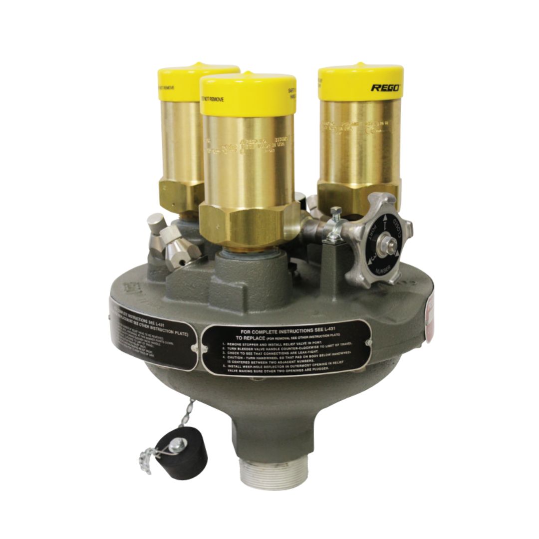 The RegO Delta Port Relief Valve Manifold 2" MPT ASME LPG 3 Reliefs is equipped with three yellow-capped cylinders and silver fittings on a gray base, making it ideal for use in LPG systems. It features labels and a handle to enhance functionality and is compatible with large stationary pressurized storage containers, working seamlessly alongside the RegO brand manifold.