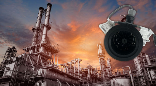 Raven flow meter positioned in front of an industrial facility at sunset, highlighting its application in managing fluid flow within complex industrial systems.