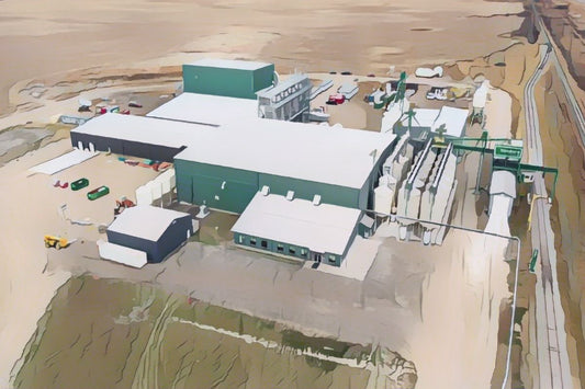 Aerial view of an industrial facility in a prairie landscape, with several green-roofed buildings and machinery.