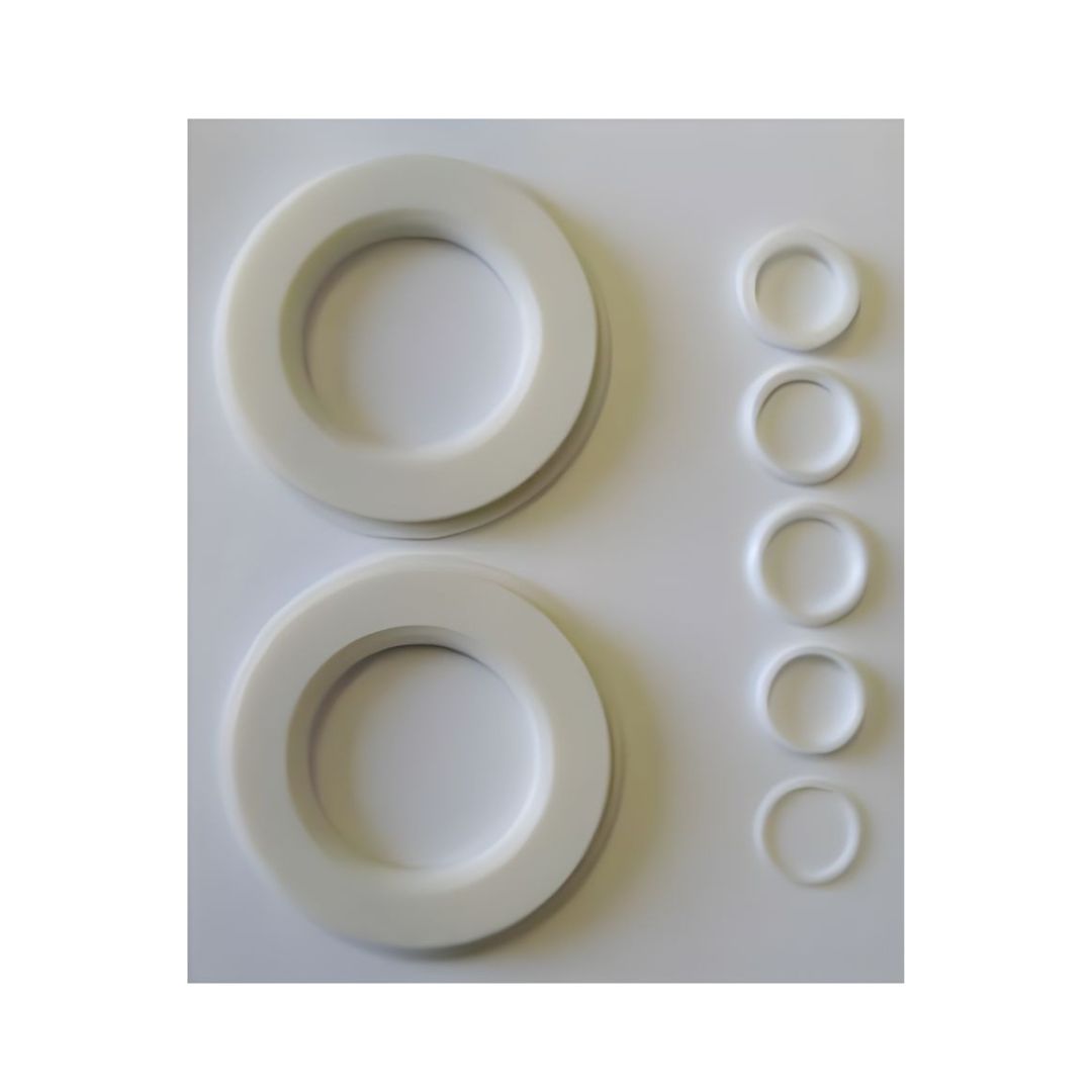 Two sets of circular rings of varying sizes, reminiscent of components from the Emico Repair Kit for a 2" 3-Piece Stainless Steel Ball Valve (4-Bolt), are arranged side by side on a pristine white background.